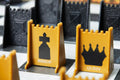 Bishop and Queen gold stealth chess pieces on game board